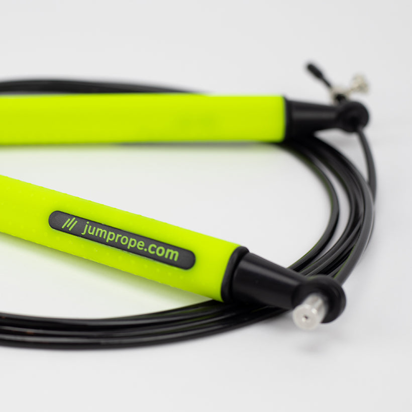 Speed Rope product photo on white and background zoomed in on the handle with jumprope.com logo in focus